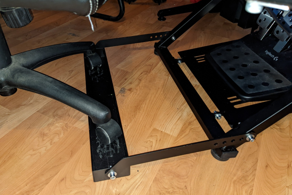 Office chair wheels tucked into racing wheel stand fixture