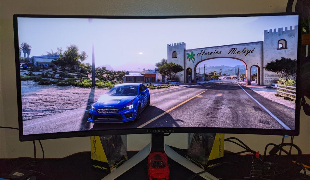 Blue Subaru in front of Mexican town Forza Horizon on Alienware OLED Monitor